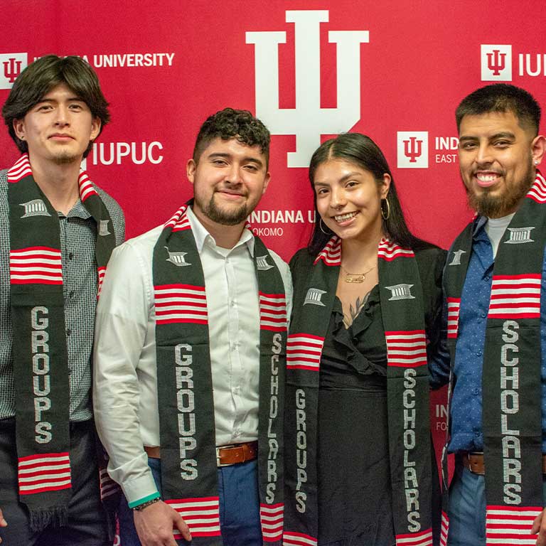 Group of recent graduates pose at graduation.